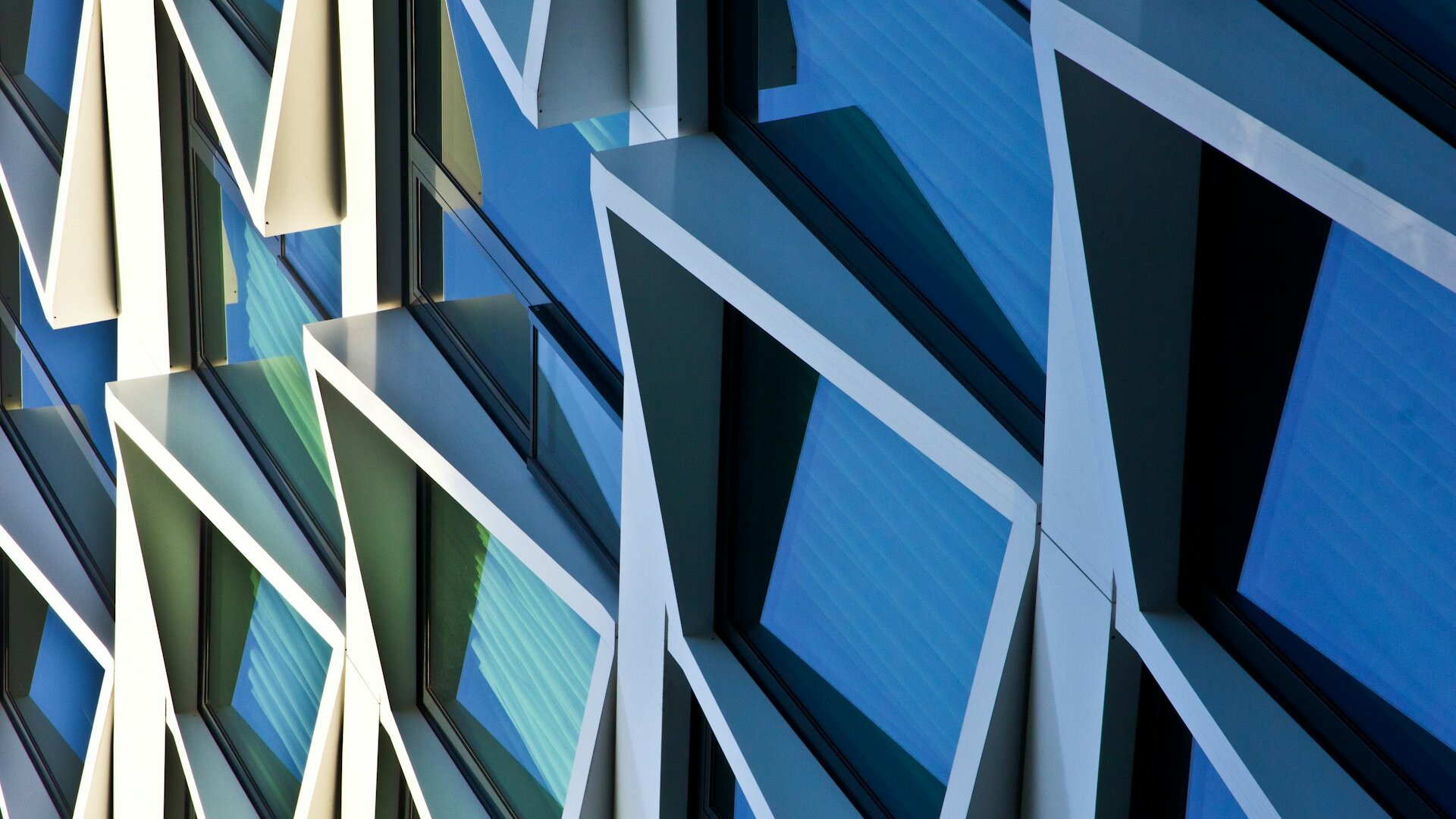 Modern glass building facade with geometric patterns and clean architectural lines