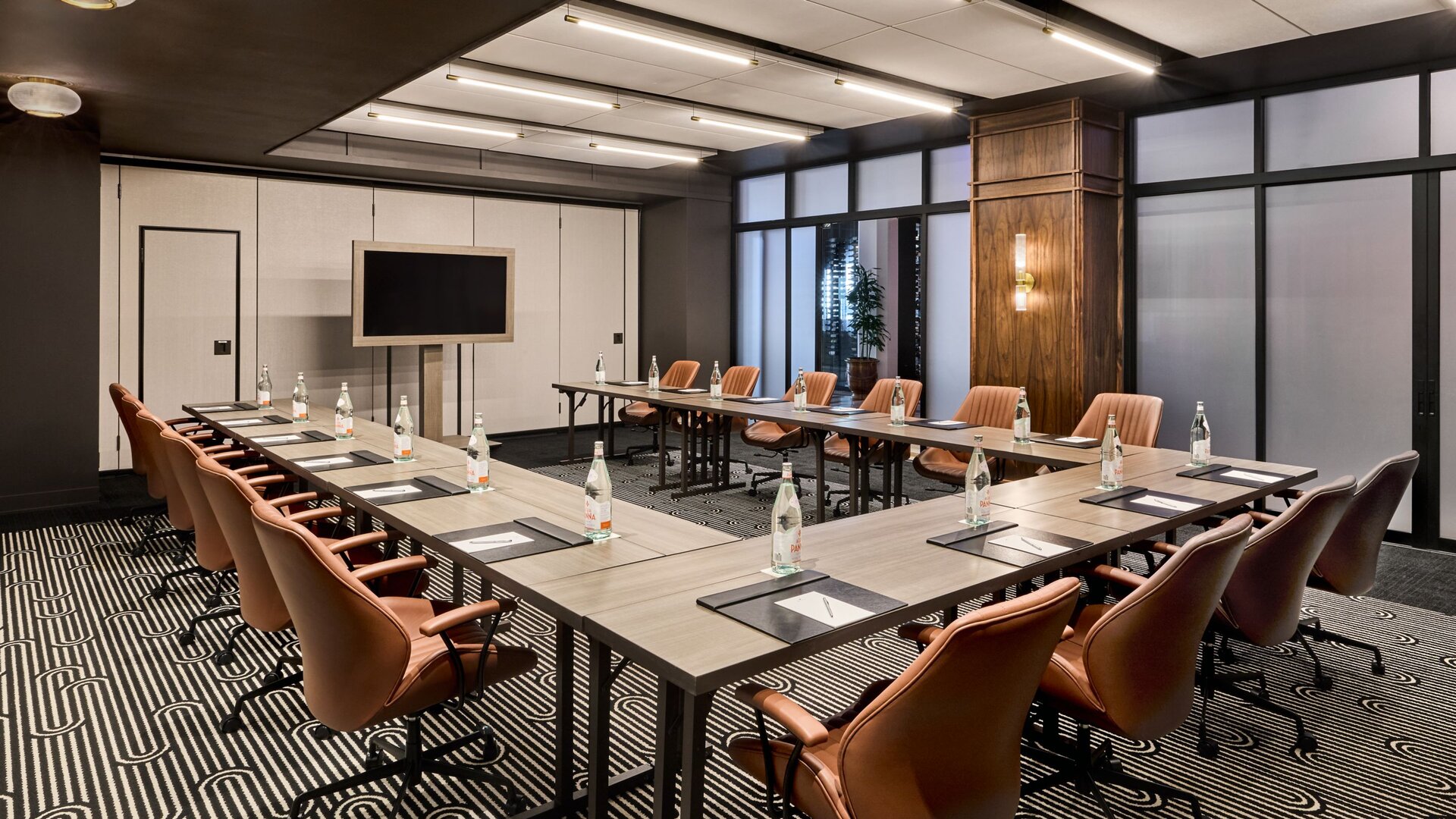 Professional modern boardroom with panoramic city skyline views through floor-to-ceiling windows